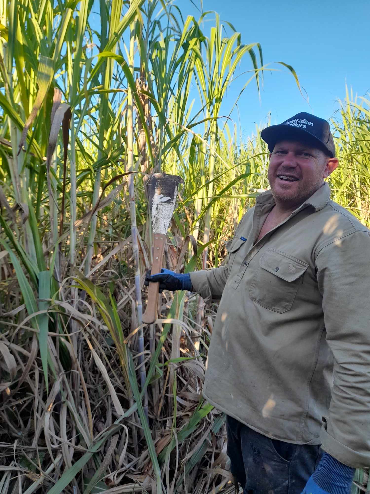 Luke in the field chopping sugar cane