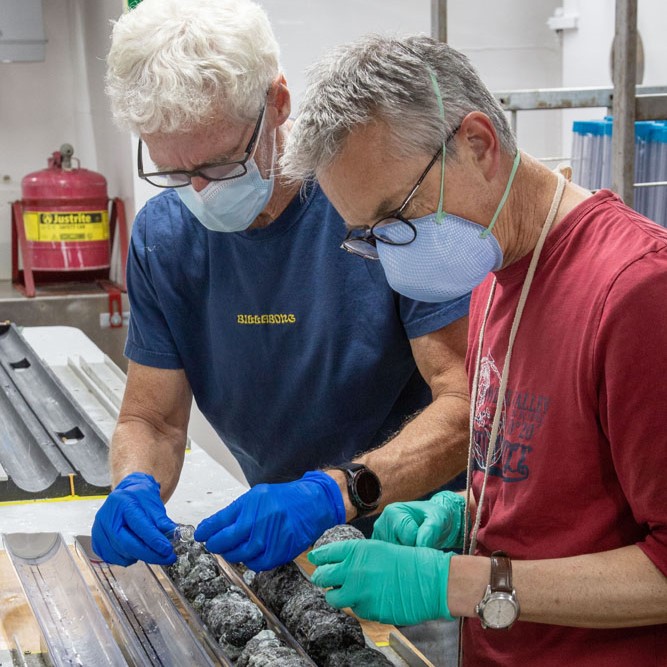 Two men inspect mantle rock fragments