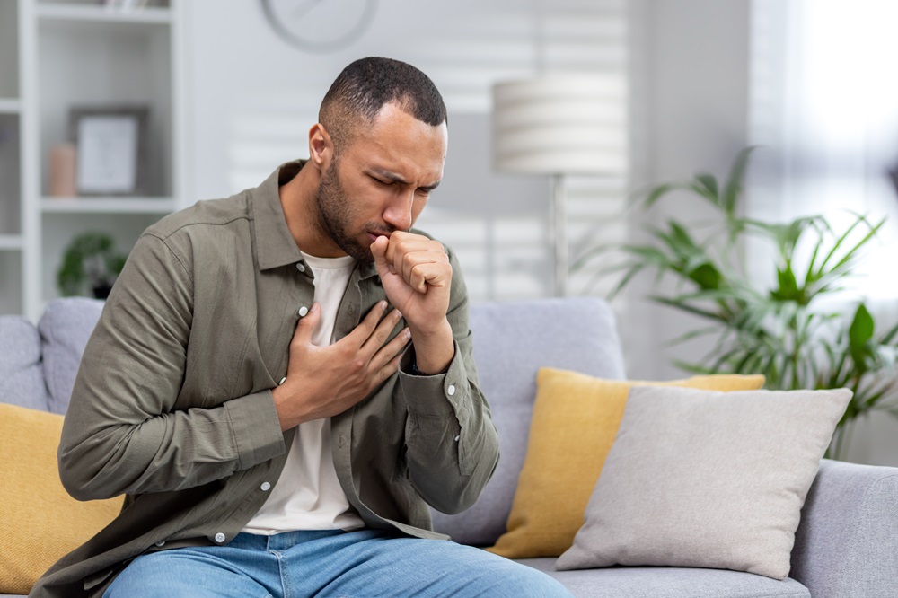 Man coughs and holds his chest