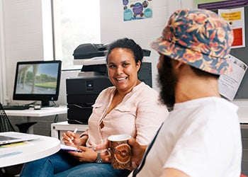 two people talking at a desk
