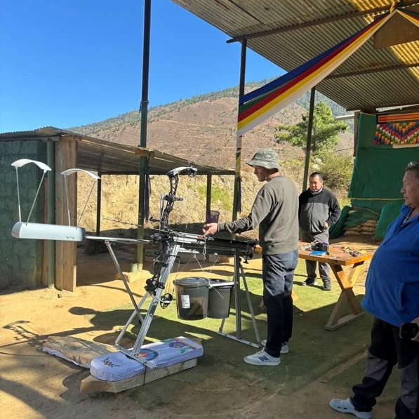 Checking arrow shooting machine settings during air density field experiment 