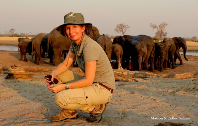 Dr Tammie Matson in front of a herd of elephants