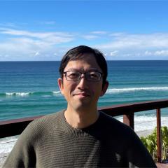 Tatsuya standing in front of a beach